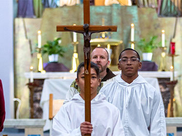 An alter server holding up a crucifix as they exit Mass An alter server holding up a crucifix as they exit Mass